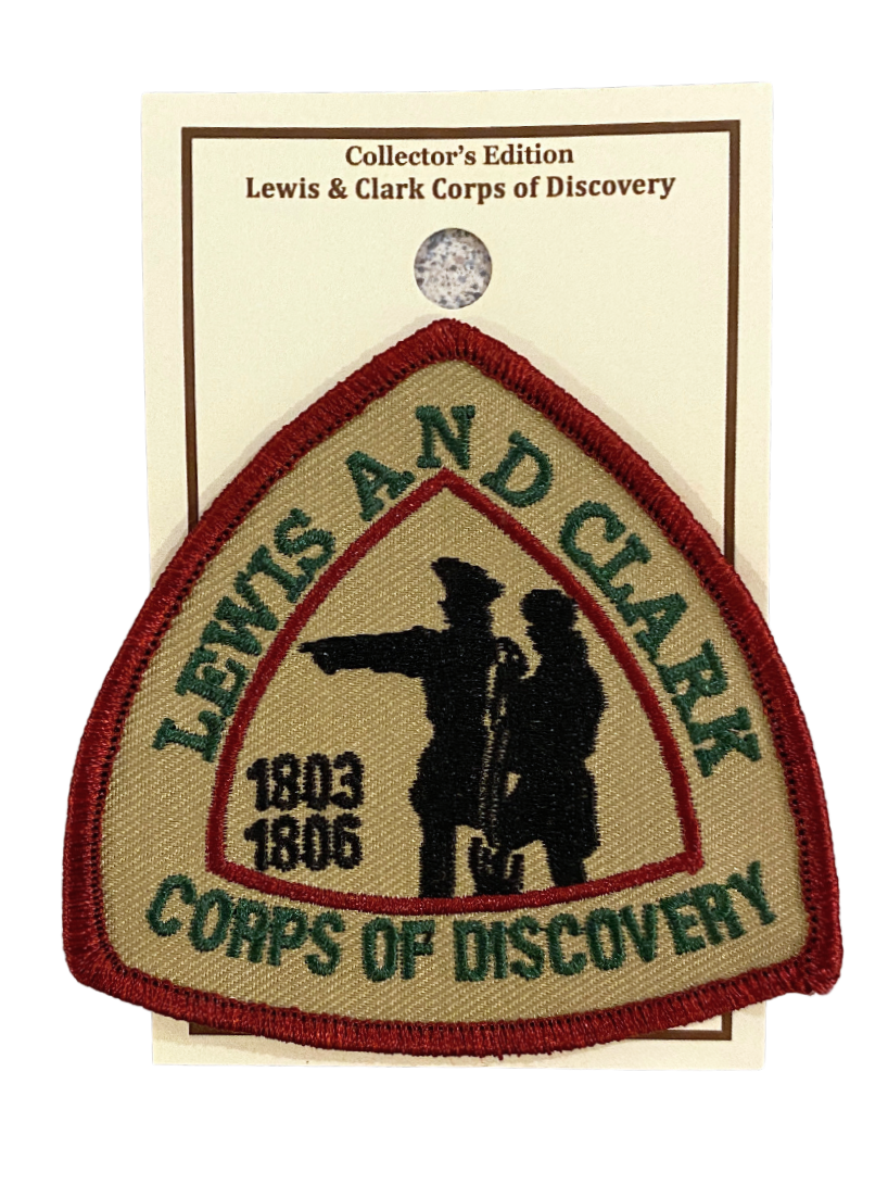A triangle patch with red border depicting Lewis and Clark pointing to the left. Text on the outside reads "Lewis and Clark Corps of Discovery" and inside "1803 1806"