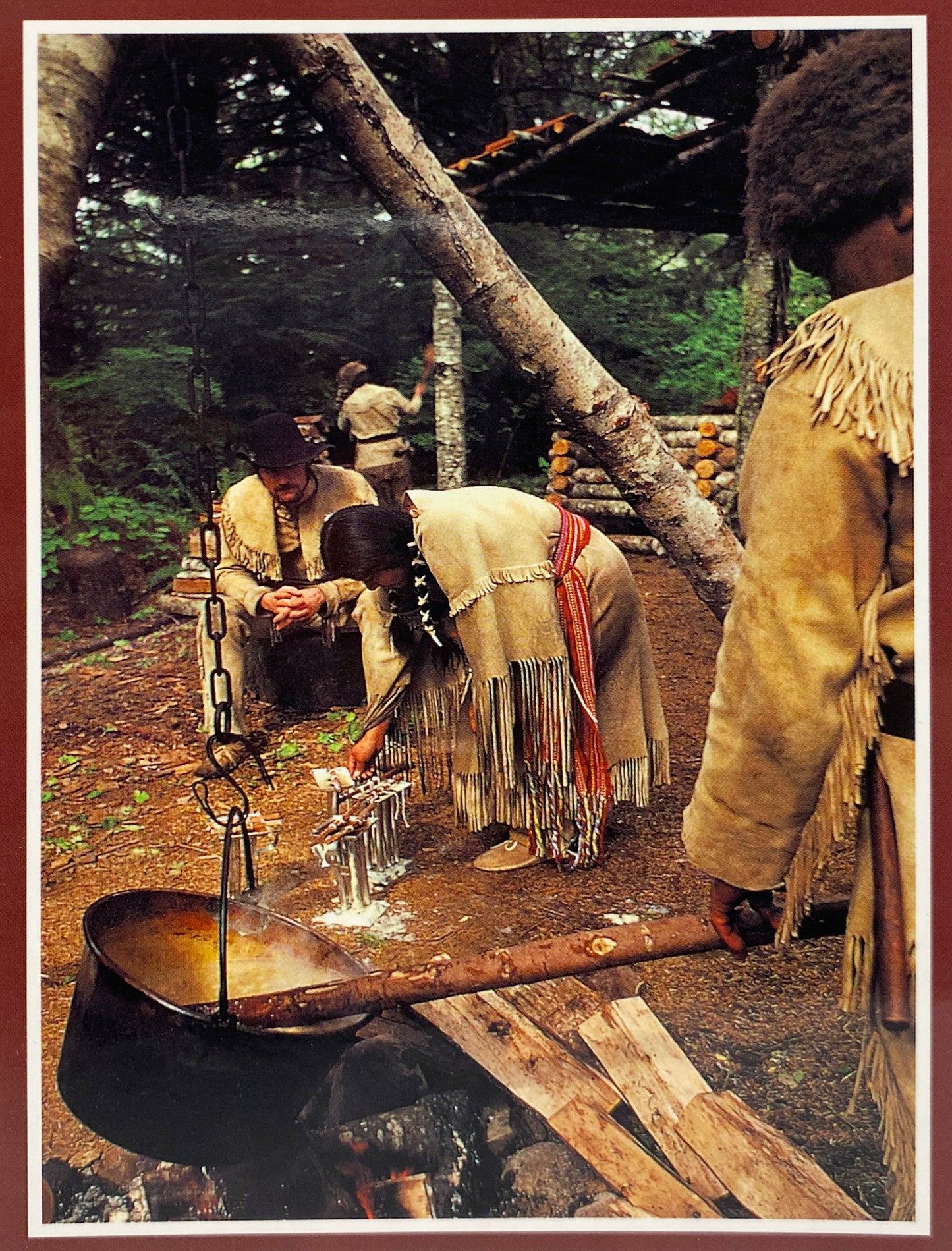 Park rangers dressed in historical clothing make candles with animal fat.