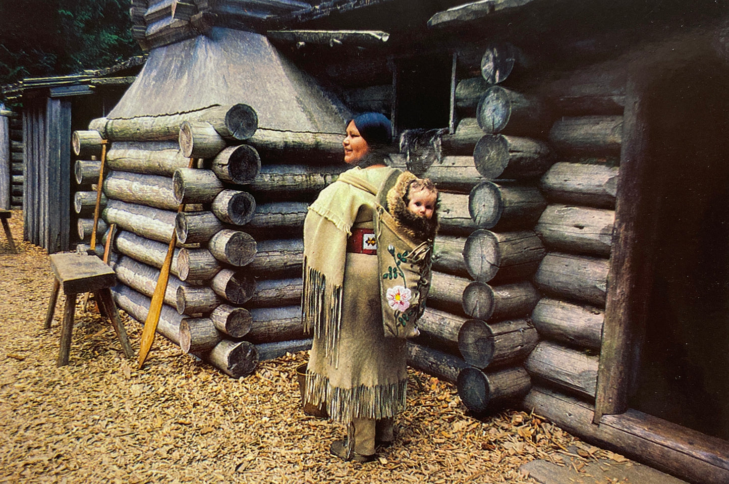 A Park Ranger dressed in historical costuming depicting Sacagawea and their child Jean Baptiste on their back.