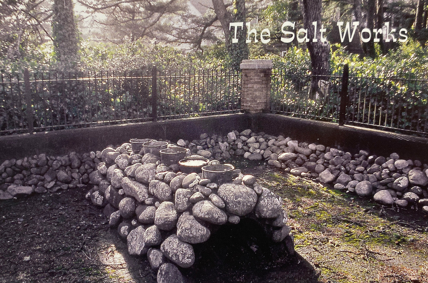 Large stones arranged into an oven with water filled pots on top. Text in the top right reads "The Salt Works."