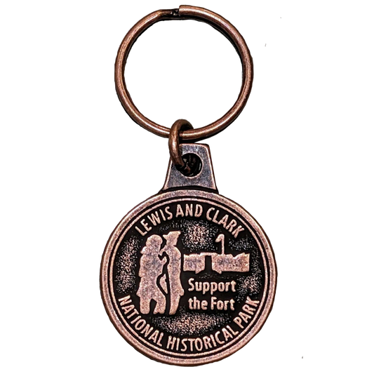 A copper keychain depicting Lewis and Clark in front of Fort Clatsop. Text above reads "Lewis and Clark," in the middle "Support the Fort," and along the bottom eads "National Historical Park"