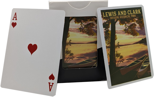 The back of a deck of playing cards depicting two canoes sitting on the side of a river with the sunset in the background. Text on top reads "Lewis and Clark National Historical Park."